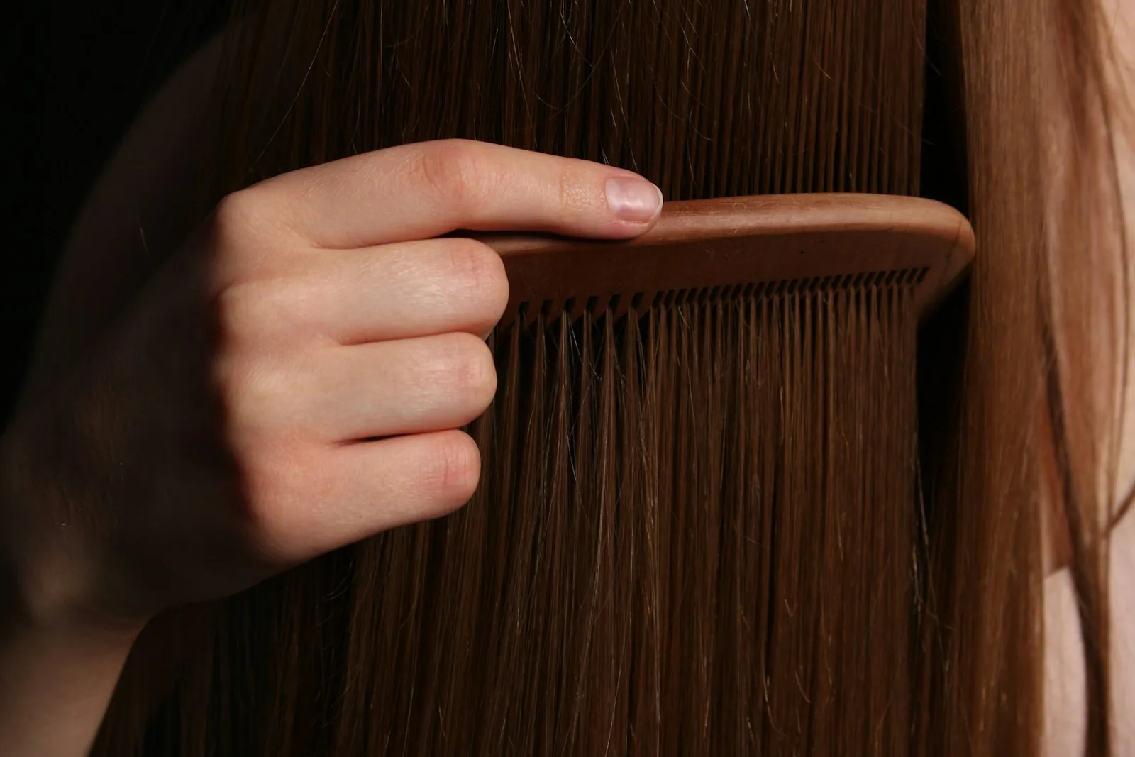 A wide tooth comb drawn through long, smooth brown hair after a keratin smoothing treatment at Salon Bastille in Montgomery, Cincinnati